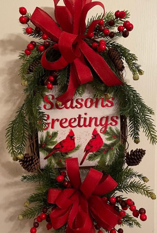 Oval Christmas wreath with “Season’s Greetings